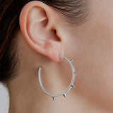 model wearing sener besim large spike earrings 
