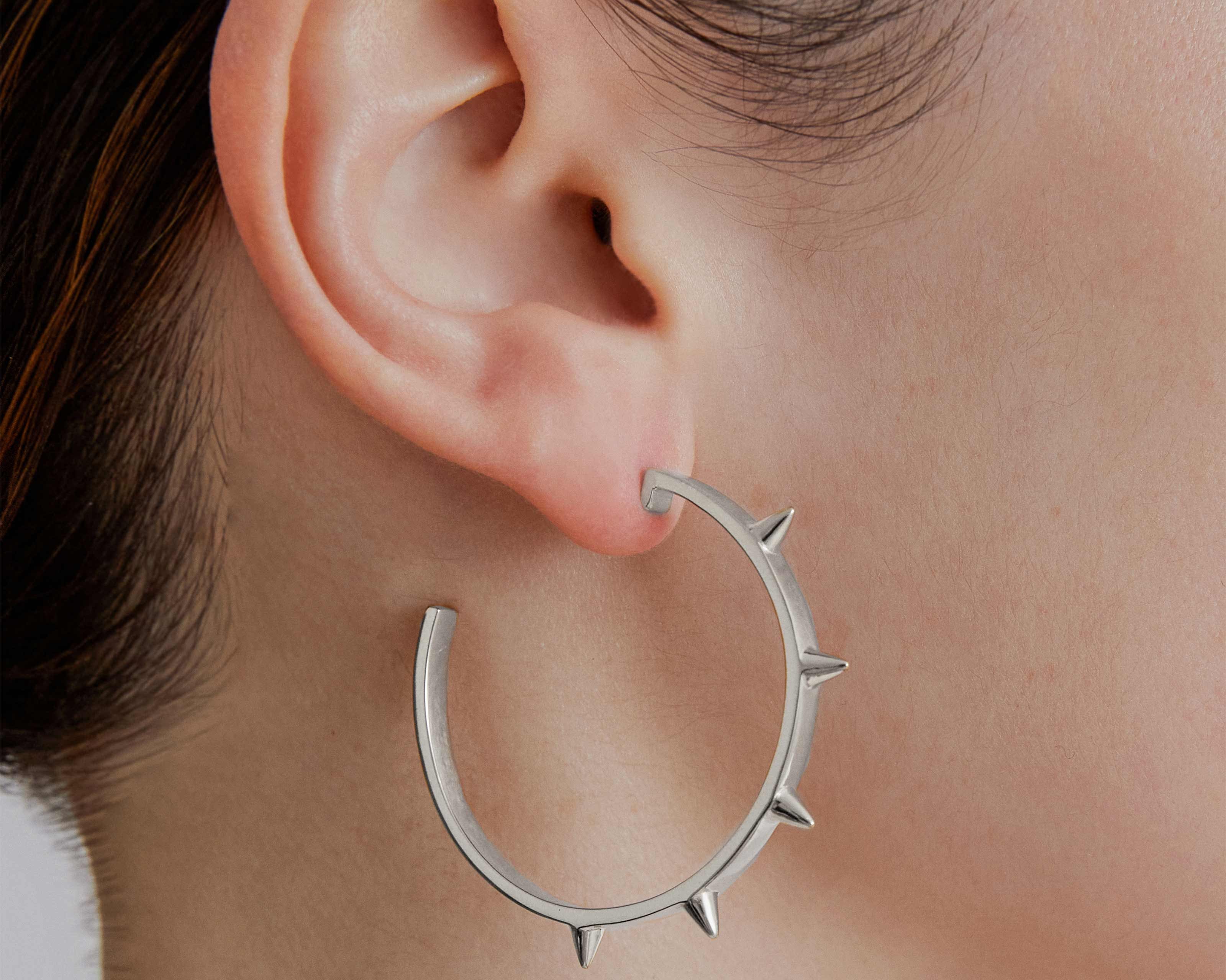 model wearing sener besim large spike earrings 