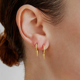 Şener Besim Medium Single Point Huggies in 14ct gold plating, worn close up on ear