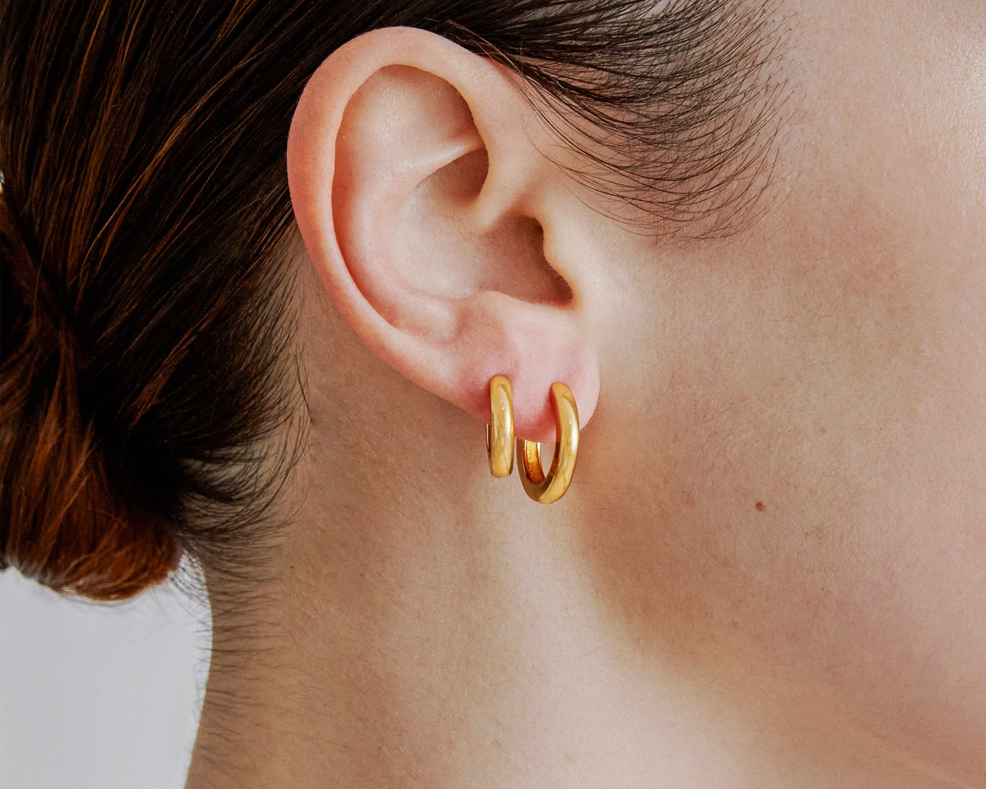 Şener Besim Medium Tube Huggies in 14ct gold plating — worn model