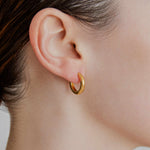 Medium gold huggie hoop earrings worn — Şener Besim Tube Series