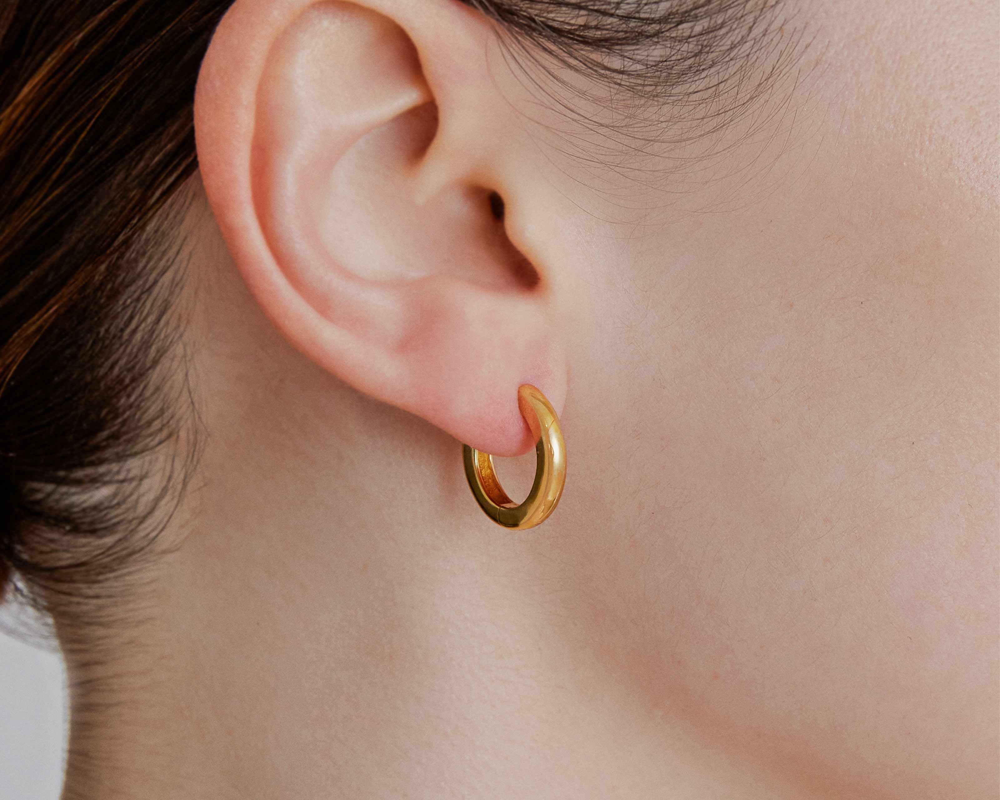 Medium gold huggie hoop earrings worn — Şener Besim Tube Series