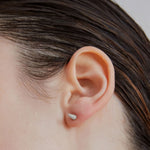 Single point spike stud earrings in silver worn on ear — Şener Besim