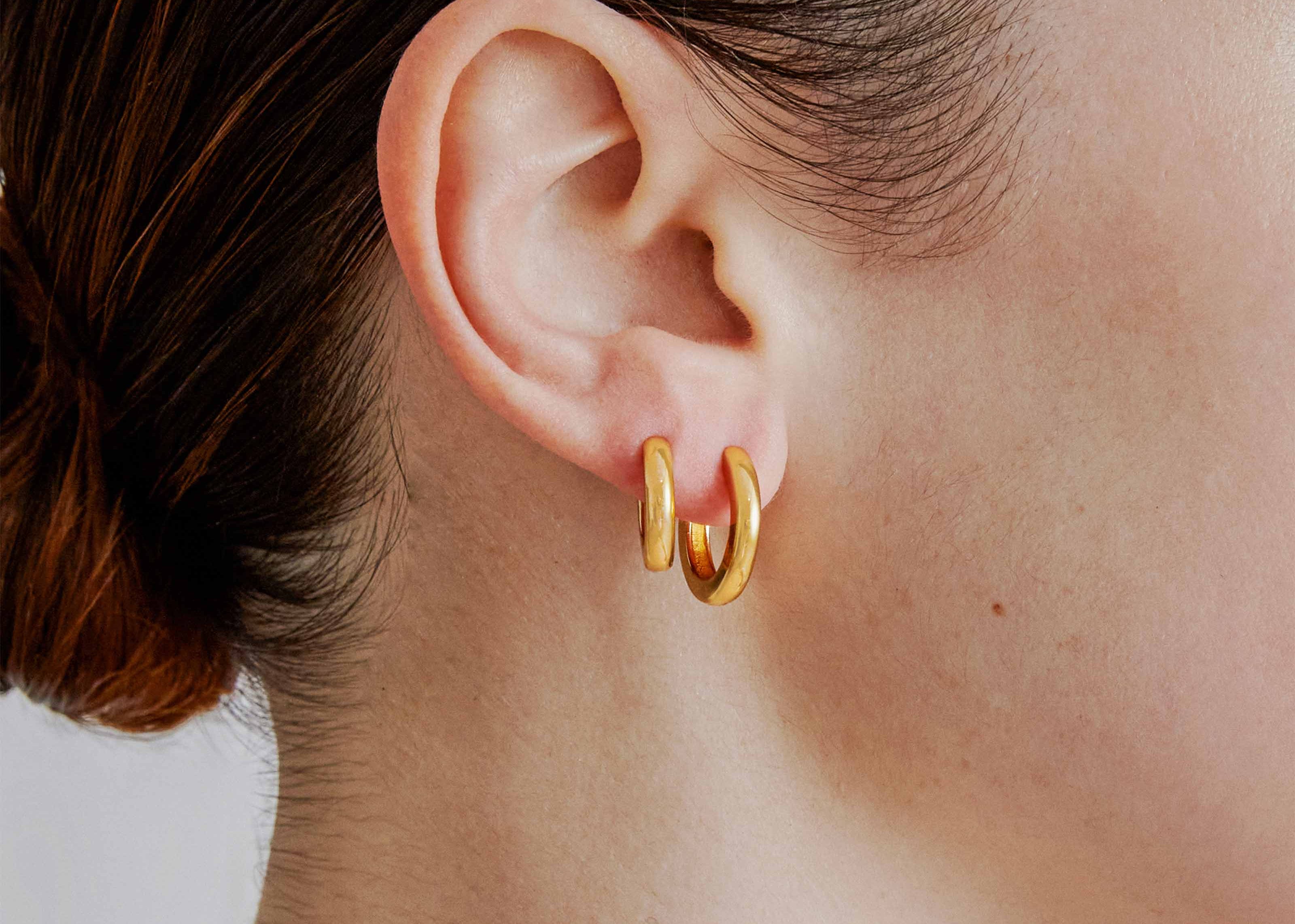 Small gold huggie hoop earrings worn — Şener Besim Tube Series