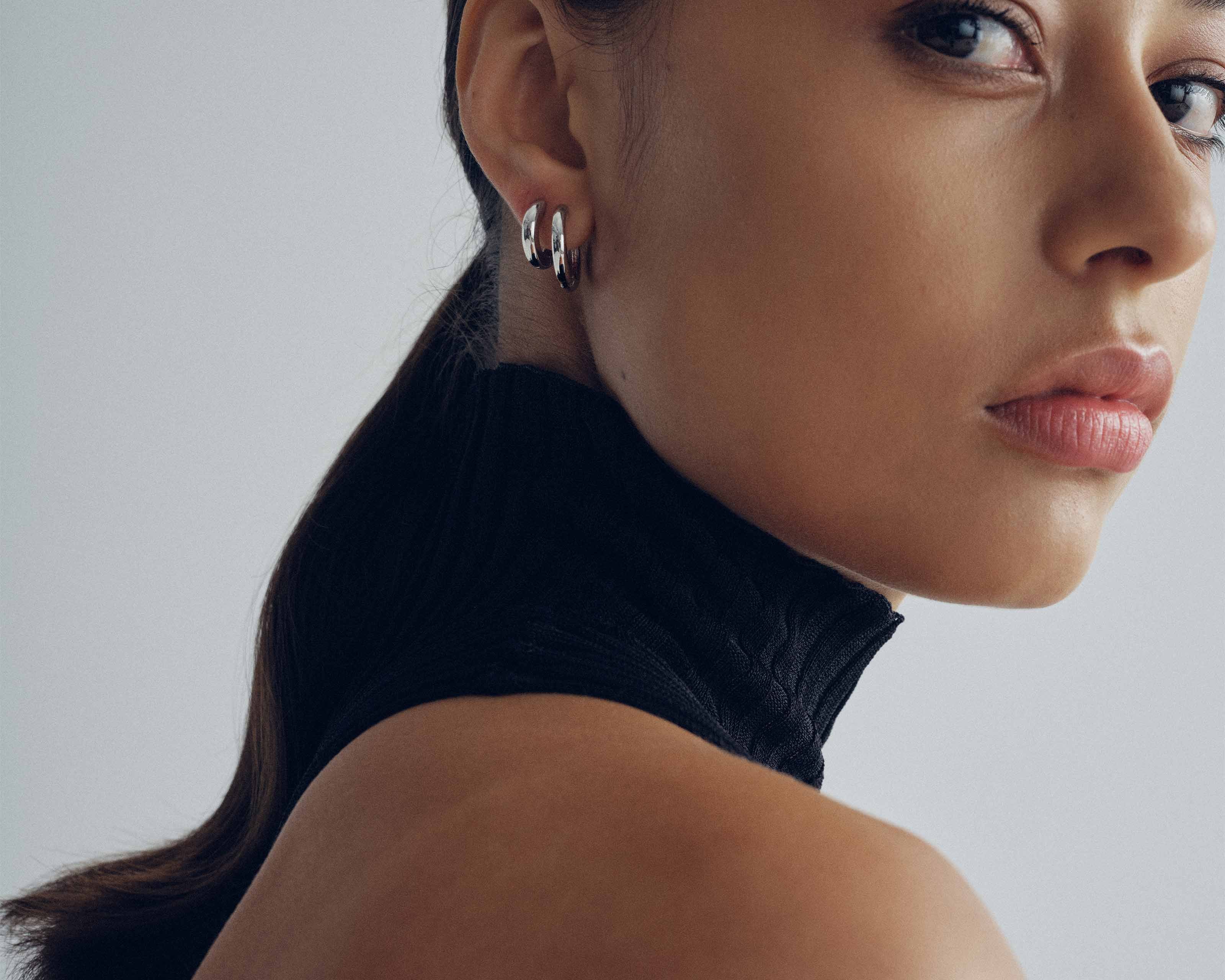 Small silver huggie hoop earrings worn — Şener Besim Tube Series